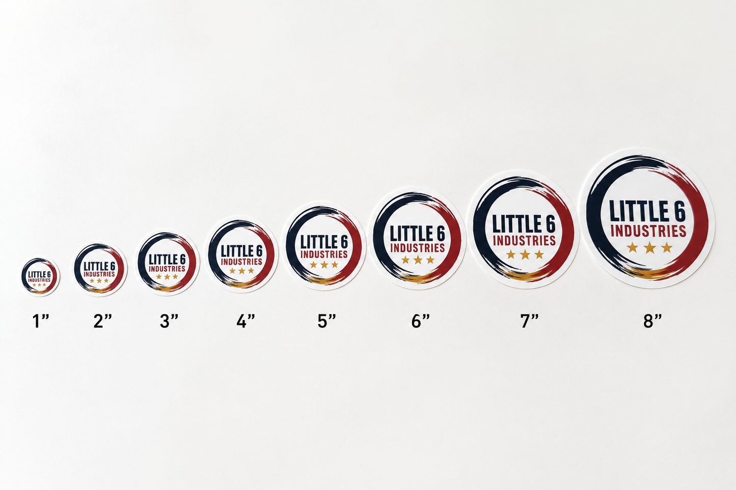 A row of circular stickers or decals labeled 1 through 8 inches, shown in increasing size on a plain white background. Each sticker has a dark navy outer ring, a red inner ring, and a white center with the text 'LITTLE 6 INDUSTRIES' and small gold stars.