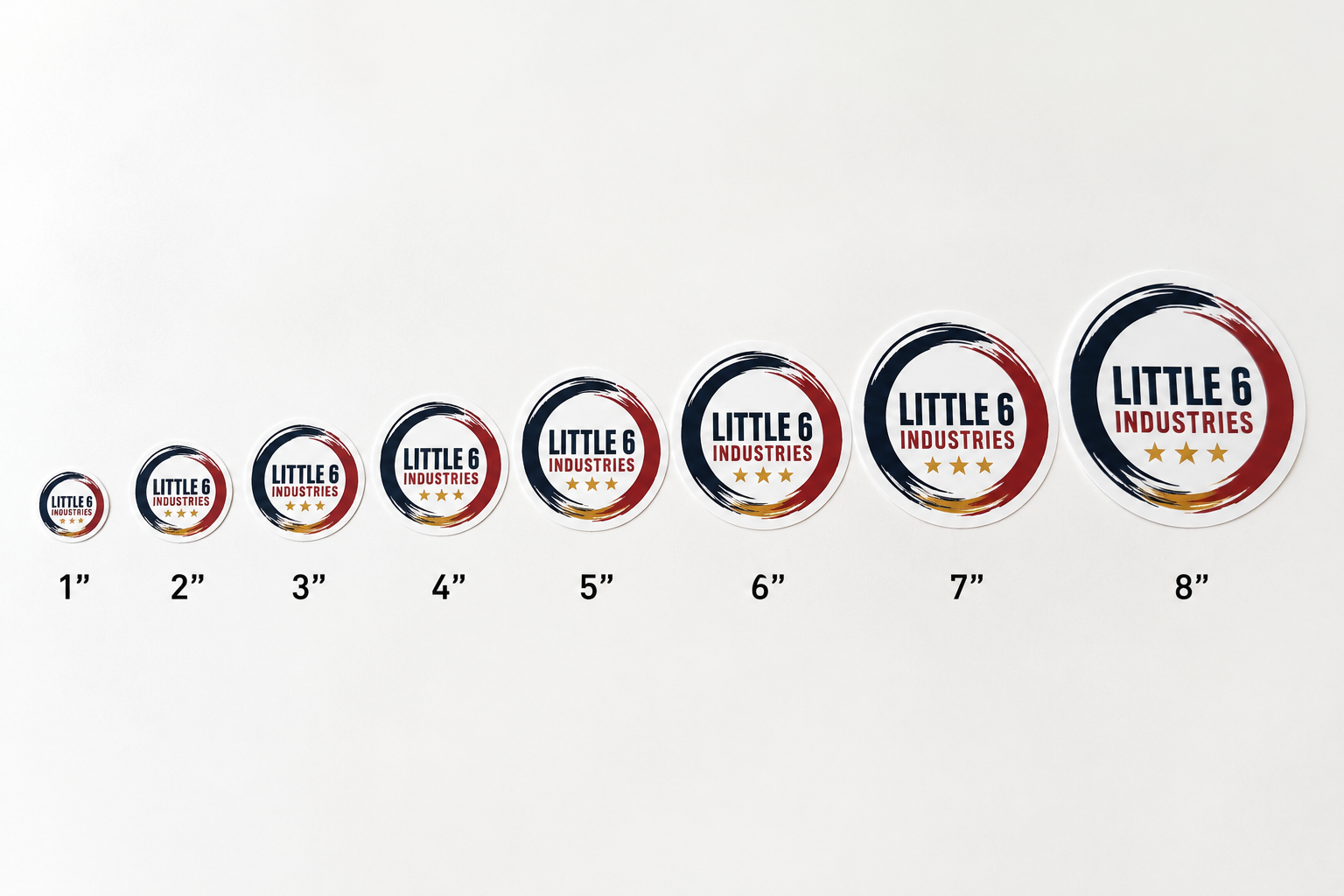 A row of circular stickers or decals labeled 1 through 8 inches, shown in increasing size on a plain white background. Each sticker has a dark navy outer ring, a red inner ring, and a white center with the text 'LITTLE 6 INDUSTRIES' and small gold stars.